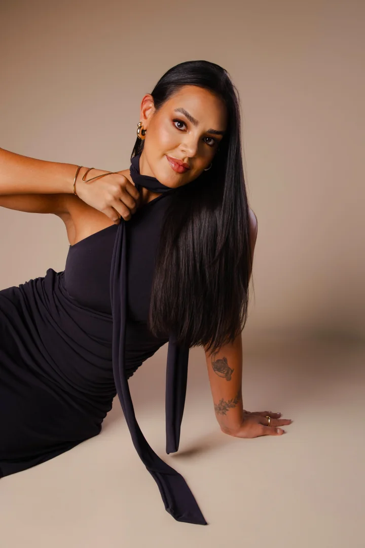 Dra. Karolyna Ribeiro sentada, com sorriso acolhedor